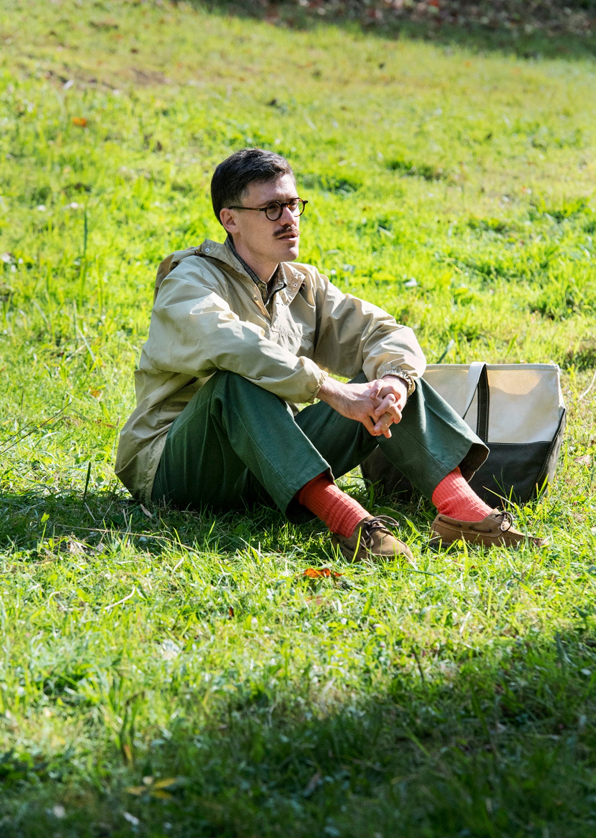 Man sitting on grass wearing Rototo Cotton Waffle Crew Socks in orange